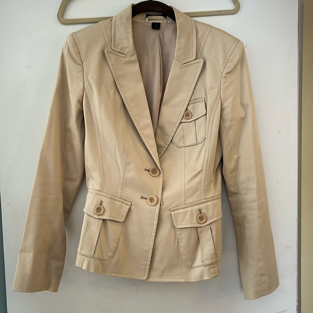 Tan fitted blazer with unique details, but still very professional.
